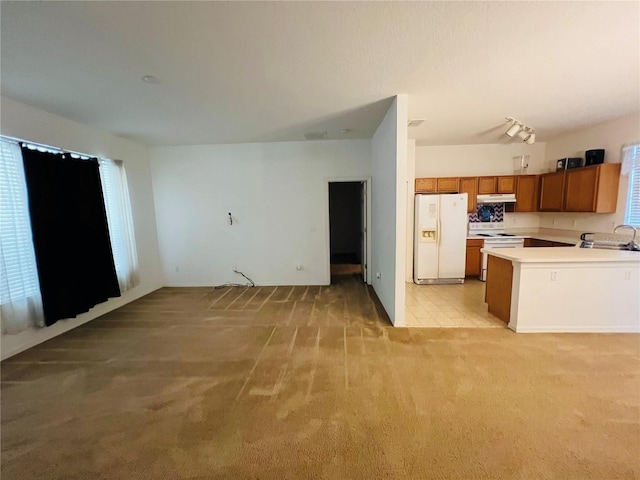 kitchen with white appliances, open floor plan, light carpet, light countertops, and under cabinet range hood