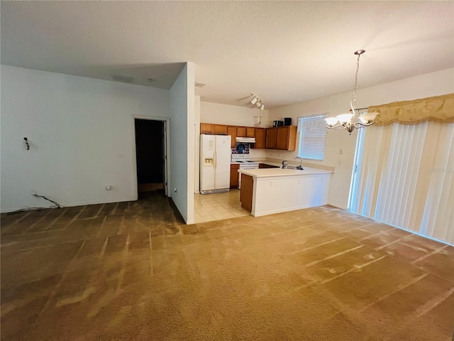 kitchen with white fridge with ice dispenser, a chandelier, light colored carpet, brown cabinetry, and open floor plan