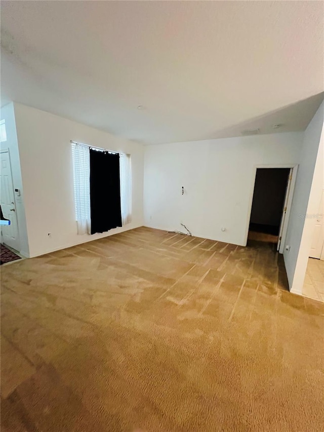 unfurnished room featuring light carpet