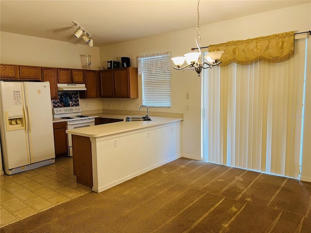 kitchen featuring white appliances, under cabinet range hood, a chandelier, light countertops, and a peninsula