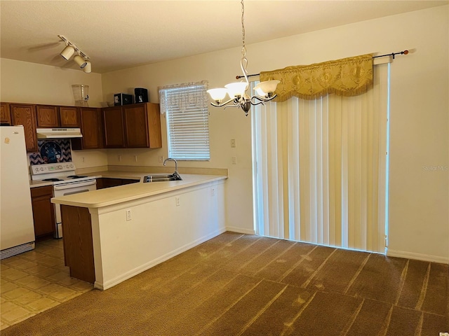 kitchen featuring white appliances, a chandelier, light countertops, a peninsula, and carpet