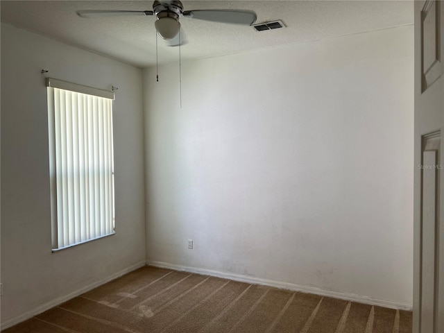 carpeted empty room featuring a ceiling fan and a textured ceiling