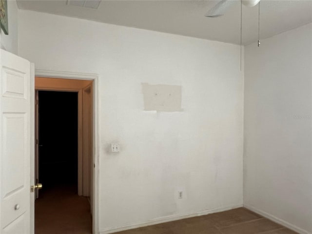 unfurnished room with ceiling fan and baseboards