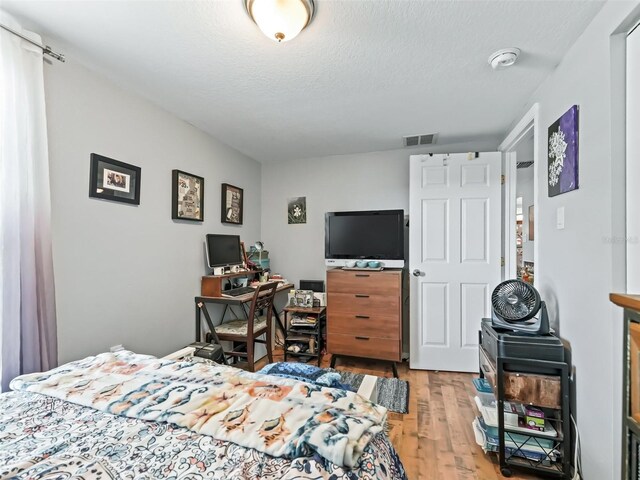 709 S Dixie Ave, Fruitland Park, FL 34731 - bedroom featuring light wood finished floors and a textured ceiling