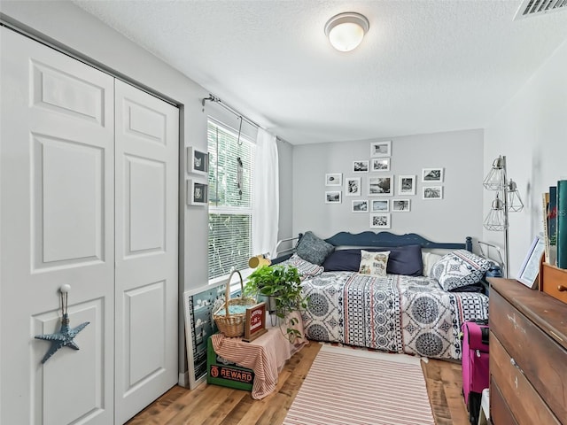 709 S Dixie Ave, Fruitland Park, FL 34731 - bedroom with a textured ceiling, wood finished floors, and a closet