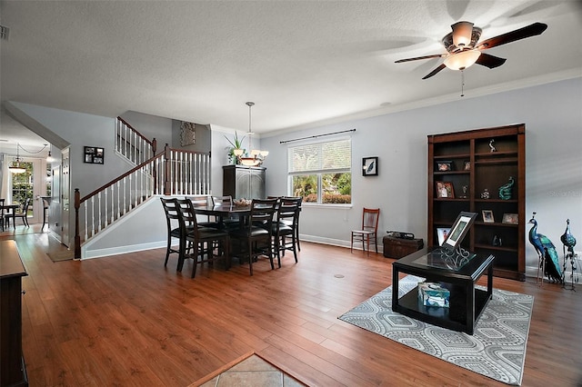 30230 Tokara Ter, Mount Dora, FL 32757 - dining space with wood finished floors, a ceiling fan, a chandelier, stairway, and ornamental molding