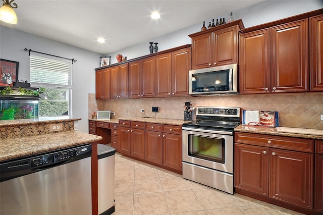 30230 Tokara Ter, Mount Dora, FL 32757 - kitchen with appliances with stainless steel finishes, light tile patterned flooring, decorative backsplash, recessed lighting, and light stone counters
