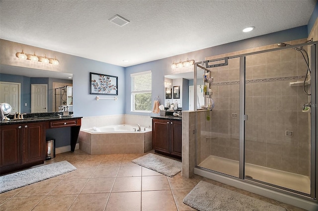 30230 Tokara Ter, Mount Dora, FL 32757 - bathroom featuring two vanities, a garden tub, a textured ceiling, a stall shower, and tile patterned flooring