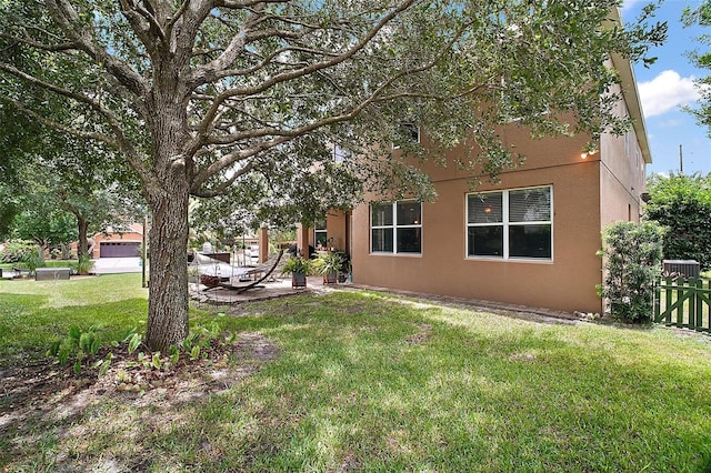30230 Tokara Ter, Mount Dora, FL 32757 - view of side of property featuring stucco siding, a lawn, and a patio area