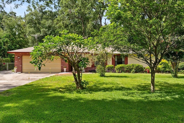 5268 Pinto Way, Orlando, FL 32810 - view of property hidden behind natural elements with concrete driveway, an attached garage, a front yard, and brick siding