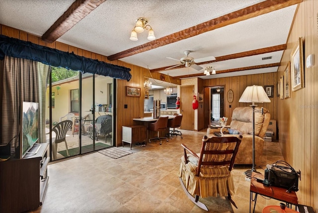 5268 Pinto Way, Orlando, FL 32810 - living area featuring beam ceiling, wooden walls, a textured ceiling, and a ceiling fan