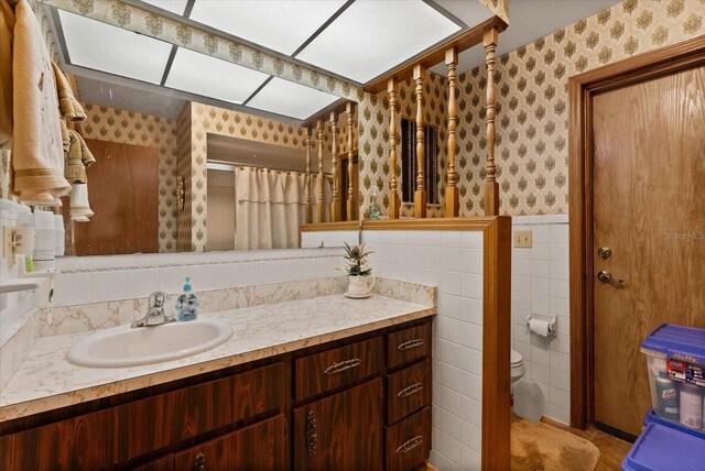 5268 Pinto Way, Orlando, FL 32810 - bathroom featuring wallpapered walls, vanity, a wainscoted wall, curtained shower, and tile walls