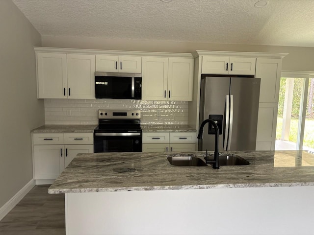 6805 N Sandborn Loop, Citrus Springs, FL 34433 - kitchen with stainless steel appliances, white cabinets, backsplash, and a textured ceiling
