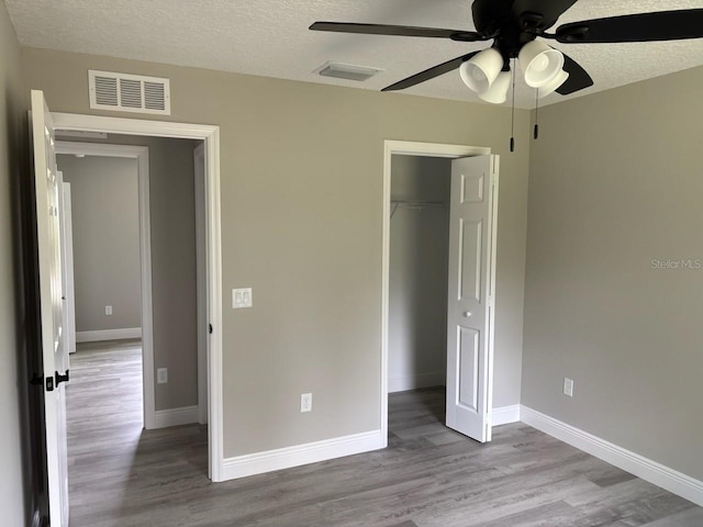 6805 N Sandborn Loop, Citrus Springs, FL 34433 - unfurnished bedroom with wood finished floors, a closet, a textured ceiling, and ceiling fan