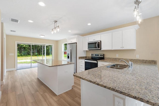 577 E Anderson Ave, Bushnell, FL 33513 - kitchen featuring stainless steel appliances, light wood-type flooring, a kitchen island, white cabinets, and recessed lighting