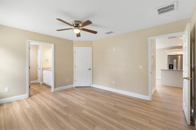 577 E Anderson Ave, Bushnell, FL 33513 - unfurnished bedroom with stainless steel fridge, light wood-style floors, ensuite bathroom, and ceiling fan