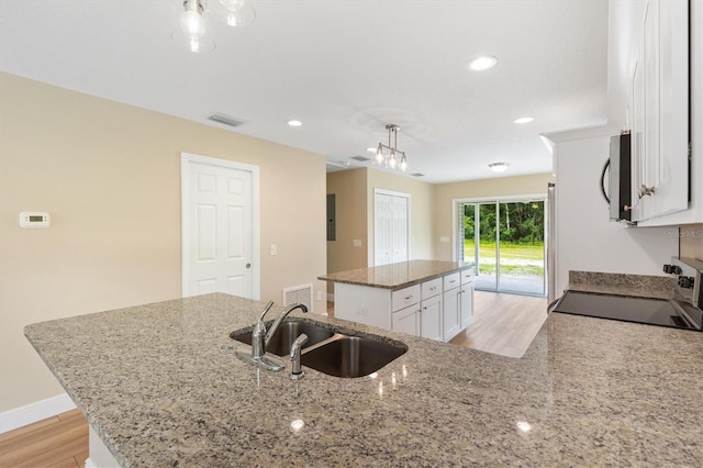 577 E Anderson Ave, Bushnell, FL 33513 - kitchen with stainless steel microwave, a center island, electric range, white cabinets, and recessed lighting