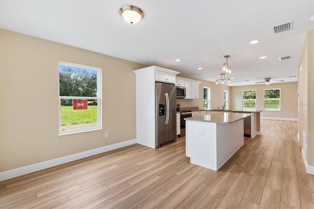 577 E Anderson Ave, Bushnell, FL 33513 - kitchen with appliances with stainless steel finishes, light wood-style floors, plenty of natural light, white cabinets, and recessed lighting