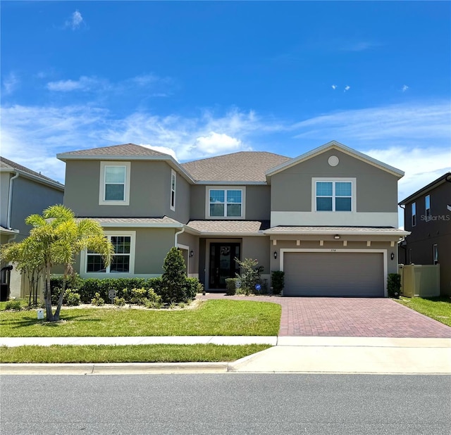 7740 Marsala St, Clermont, FL 34714 - traditional-style home with stucco siding, decorative driveway, an attached garage, and a front lawn