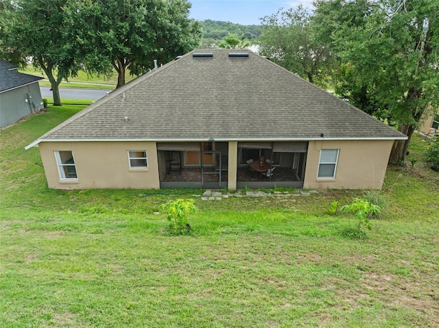 1532 Nightfall Dr, Clermont, FL 34711 - rear view of house featuring a shingled roof, a lawn, a sunroom, and stucco siding