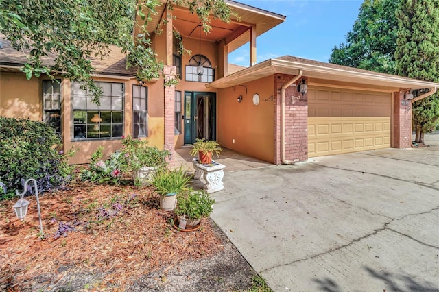 9835 Lakeshore Dr, Clermont, FL 34711 - view of front of home with stucco siding, an attached garage, driveway, brick siding, and roof with shingles