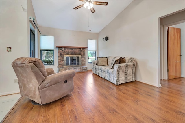9835 Lakeshore Dr, Clermont, FL 34711 - living area featuring a ceiling fan, wood finished floors, high vaulted ceiling, and a brick fireplace