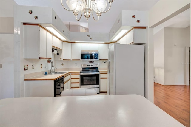 9835 Lakeshore Dr, Clermont, FL 34711 - kitchen with stainless steel appliances, a chandelier, light wood-type flooring, light countertops, and white cabinets