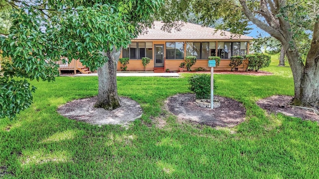 9835 Lakeshore Dr, Clermont, FL 34711 - rear view of house featuring a sunroom, a lawn, a shingled roof, and a deck