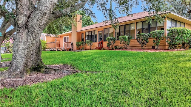 9835 Lakeshore Dr, Clermont, FL 34711 - back of property with a yard, a wooden deck, and a chimney