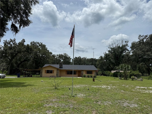 2747 County Road 615, Bushnell, FL 33513 - view of front of house featuring a front lawn, a chimney, view of scattered trees, and a carport