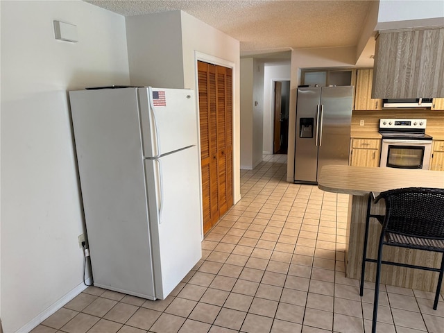 2747 County Road 615, Bushnell, FL 33513 - kitchen with stainless steel appliances, light tile patterned floors, light countertops, exhaust hood, and a textured ceiling