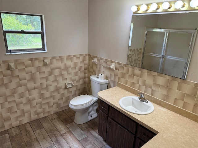 2747 County Road 615, Bushnell, FL 33513 - full bath with a stall shower, vanity, tile walls, wood finished floors, and a wainscoted wall