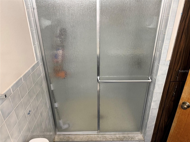 2747 County Road 615, Bushnell, FL 33513 - full bath featuring tile walls, a stall shower, and wainscoting