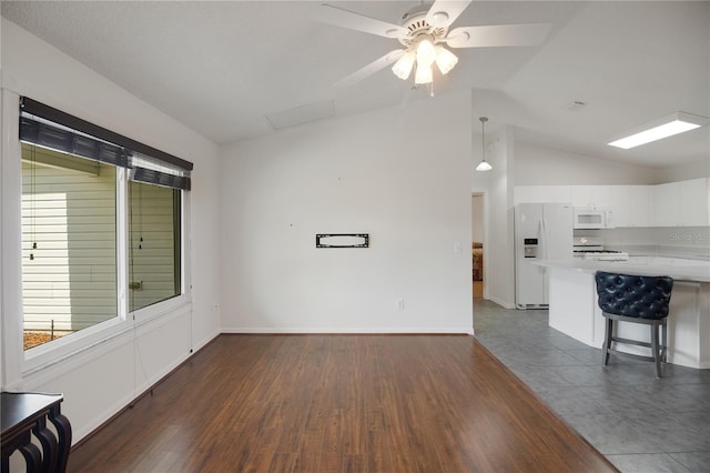 17707 SE 92nd Grantham Ter, The Villages, FL 32162 - unfurnished living room featuring vaulted ceiling, a ceiling fan, dark wood-type flooring, and healthy amount of natural light
