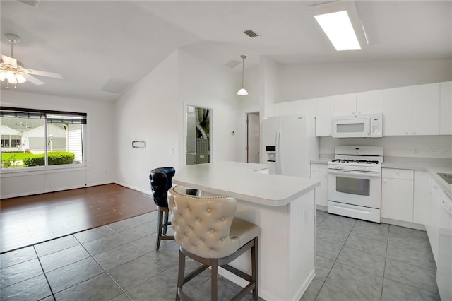 17707 SE 92nd Grantham Ter, The Villages, FL 32162 - kitchen featuring white appliances, lofted ceiling, light tile patterned flooring, light countertops, and a breakfast bar