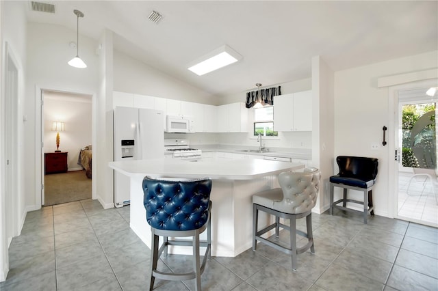 17707 SE 92nd Grantham Ter, The Villages, FL 32162 - kitchen featuring white appliances, lofted ceiling, light countertops, a breakfast bar, and a kitchen island
