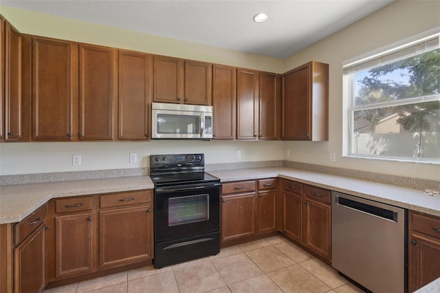 2215 Natoma Blvd, Mount Dora, FL 32757 - kitchen featuring appliances with stainless steel finishes, light tile patterned floors, light countertops, recessed lighting, and brown cabinets