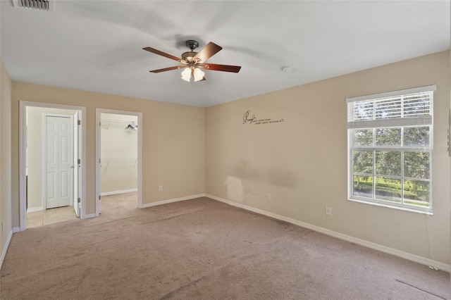 2215 Natoma Blvd, Mount Dora, FL 32757 - unfurnished bedroom featuring light carpet, a ceiling fan, and a walk in closet