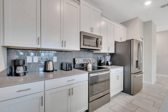 8971 Cabot Cliffs Dr, Davenport, FL 33896 - kitchen featuring stainless steel appliances, white cabinetry, decorative backsplash, light countertops, and recessed lighting