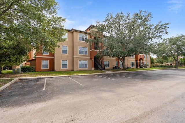 5518 Metrowest Blvd Unit 11-302, Orlando, FL 32811 - view of property with uncovered parking and stairs