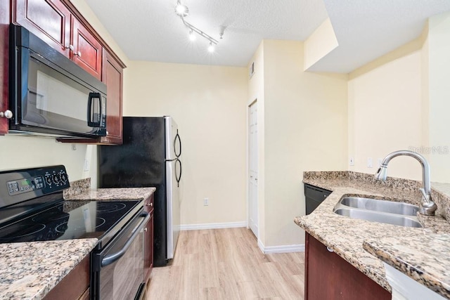 5518 Metrowest Blvd Unit 11-302, Orlando, FL 32811 - kitchen featuring black appliances, light wood-style flooring, light stone counters, dark brown cabinets, and a textured ceiling