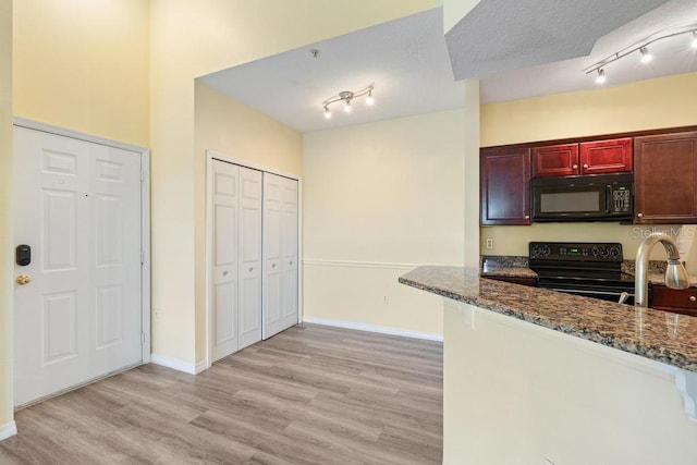 5518 Metrowest Blvd Unit 11-302, Orlando, FL 32811 - kitchen featuring black appliances, rail lighting, and dark stone counters