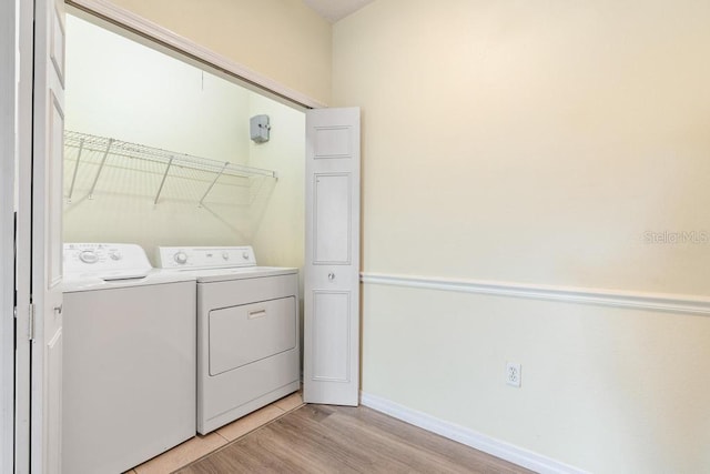 5518 Metrowest Blvd Unit 11-302, Orlando, FL 32811 - laundry room featuring independent washer and dryer and light wood-style floors