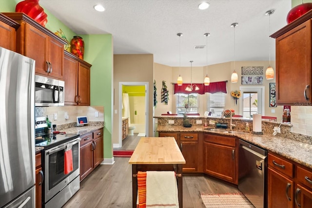 406 Benjamin Ct, Fruitland Park, FL 34731 - kitchen featuring stainless steel appliances, tasteful backsplash, light wood-type flooring, a peninsula, and recessed lighting
