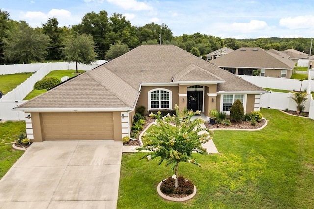 406 Benjamin Ct, Fruitland Park, FL 34731 - view of front of home with a shingled roof, an attached garage, stucco siding, driveway, and a fenced backyard