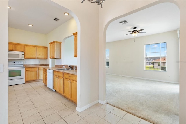12205 SE 173rd Pl, Summerfield, FL 34491 - kitchen with white appliances, ceiling fan, arched walkways, light colored carpet, and light tile patterned floors