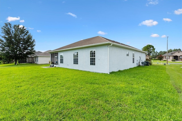 12205 SE 173rd Pl, Summerfield, FL 34491 - rear view of house featuring stucco siding and a yard
