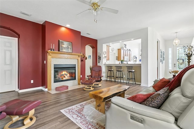 5135 Indian Ocean Loop, Tavares, FL 32778 - living area with arched walkways, wood finished floors, a tiled fireplace, ceiling fan, and recessed lighting