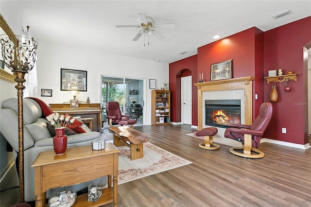 5135 Indian Ocean Loop, Tavares, FL 32778 - living room featuring a tiled fireplace, arched walkways, wood finished floors, ceiling fan, and recessed lighting