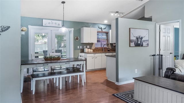 11746 Oswalt Rd, Clermont, FL 34711 - kitchen with dark countertops, white cabinets, french doors, wood finished floors, and hanging light fixtures